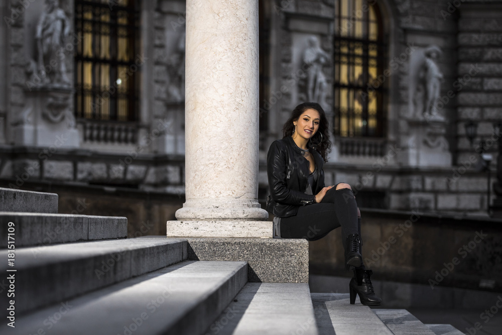 Lifestyle portrait of a woman wearing black jeans and leather jacket