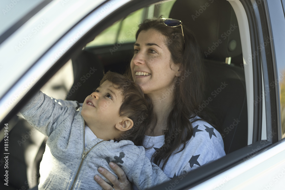 mother with his little son inside a car parking mother with his little son inside a car parking
