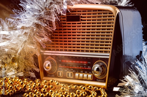 radio receiver in retro style with christmas decorations and light beams on black background