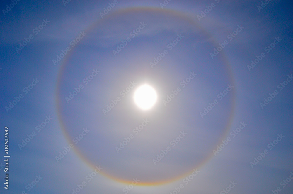 A halo around the sun in the middle of the day. Blue sky and foggy clouds. A halo around the sun in the middle of the day. Blue sky and foggy clouds.