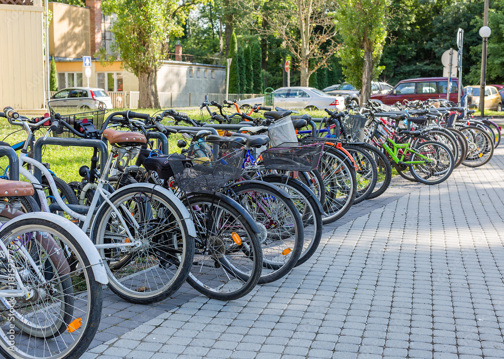 Row of bicycles standing in the parking lot near the park. Sport and healthy lifestyle concept