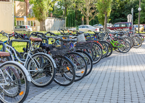 Row of bicycles standing in the parking lot near the park. Sport and healthy lifestyle concept