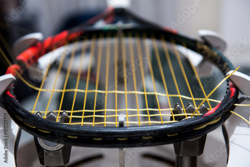 Stringing tennis racquet on professional electrical stringing machine