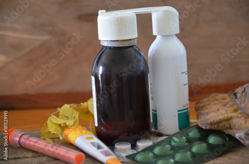 Different drugs on wooden background.Alternative remedies and traditional pills to treat colds and flu. Natural medicine and conventional medicine concept.