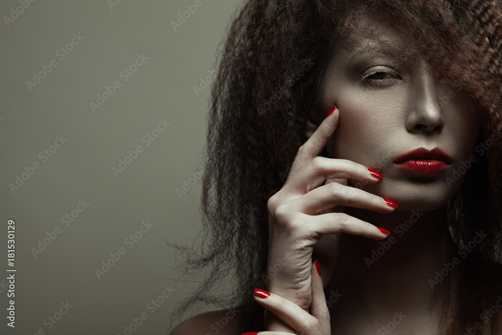 Φωτογραφία Emotive portrait of fashionable model with african style hair posing over grey background