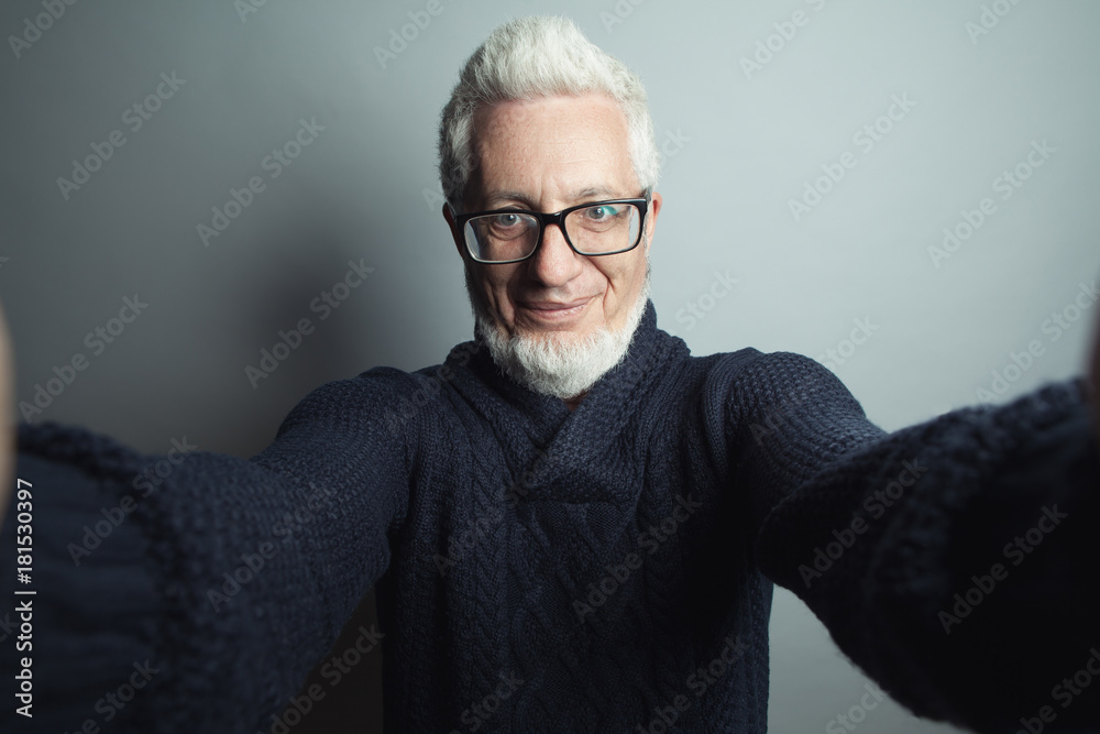 Obraz premium Fabulous at any age. Self-portrait concept. Eyewear concept. Portrait of a handsome mature man looking at camera in his hands. Close up. Studio shot