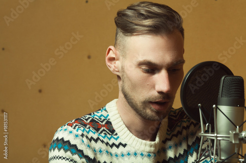 Radio dj concept. Portrait of handsome young man with blond hair hosting show, reading news live in studio. Close up. Copy-space