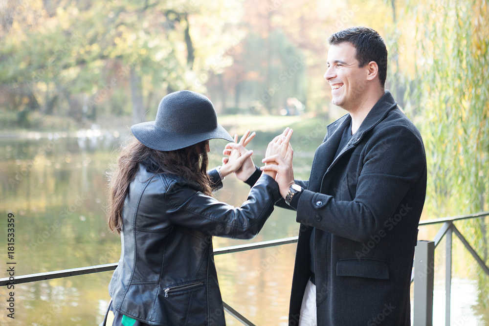 Gourgeous dancing couple walking in autumn park near a lake Gourgeous dancing couple walking in autumn park near a lake