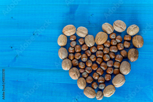 Healthy organic nuts with heart shaped on blue background 