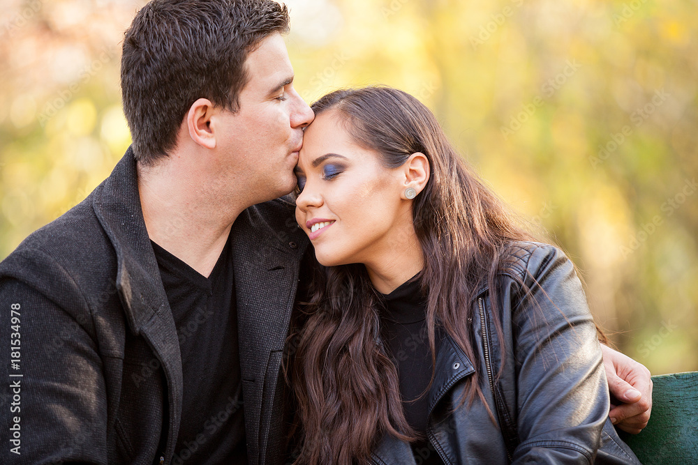 Close up of beautiful in love couple sitting on a bench in autumn park Close up of beautiful in love couple sitting on a bench in autumn park