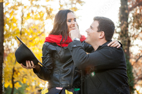 Romantic couple in autumn park smiling and having fun