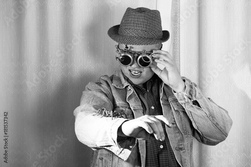 A man in goggles looks at the spider sitting on his arm, steampunk style, black and white photo