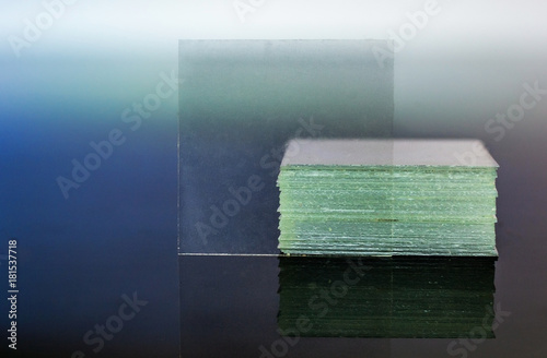 Microscope coverslip glass reflecting on glass table closeup