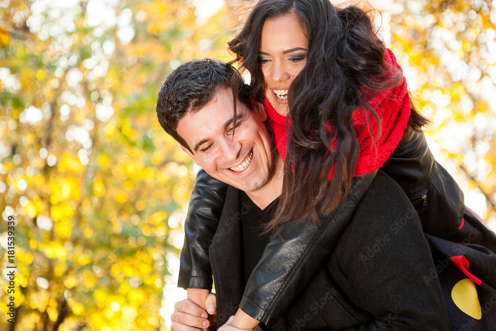 Fototapeta premium Amazing funny young couple in autumn park having fun
