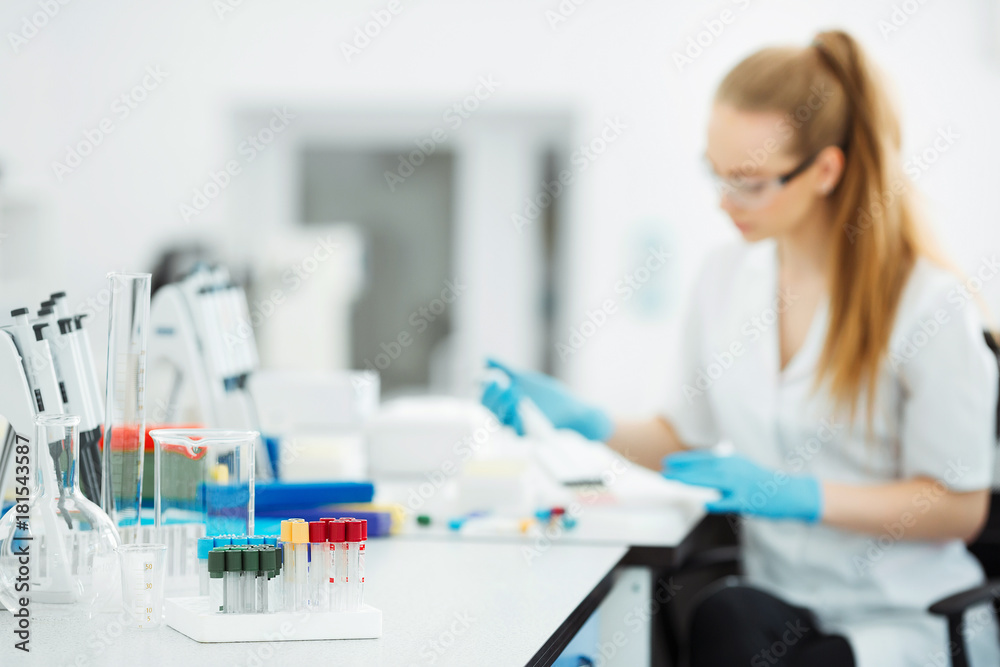 Pipette dropping a sample in a test tube. Laboratory assistant