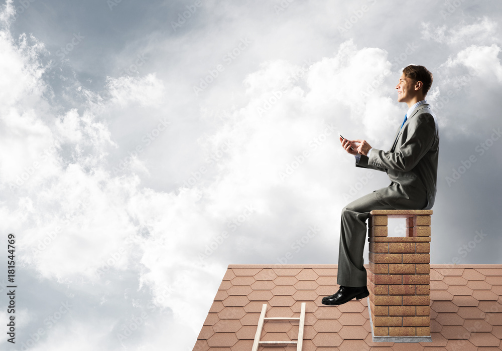 Businessman or student on brick roof smiling and making calls Businessman or student on brick roof smiling and making calls