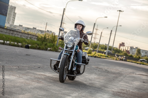 Female motorcyclist driving solo on asphalt road on motorbike