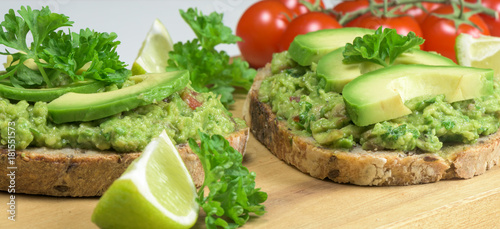 Healthy dish - guacamole sandwich on the wooden board- closeup.