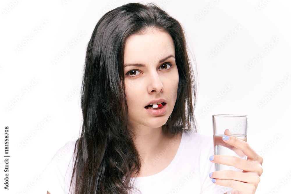 Young woman on white isolated background holds a pill Young woman on white isolated background holds a pill
