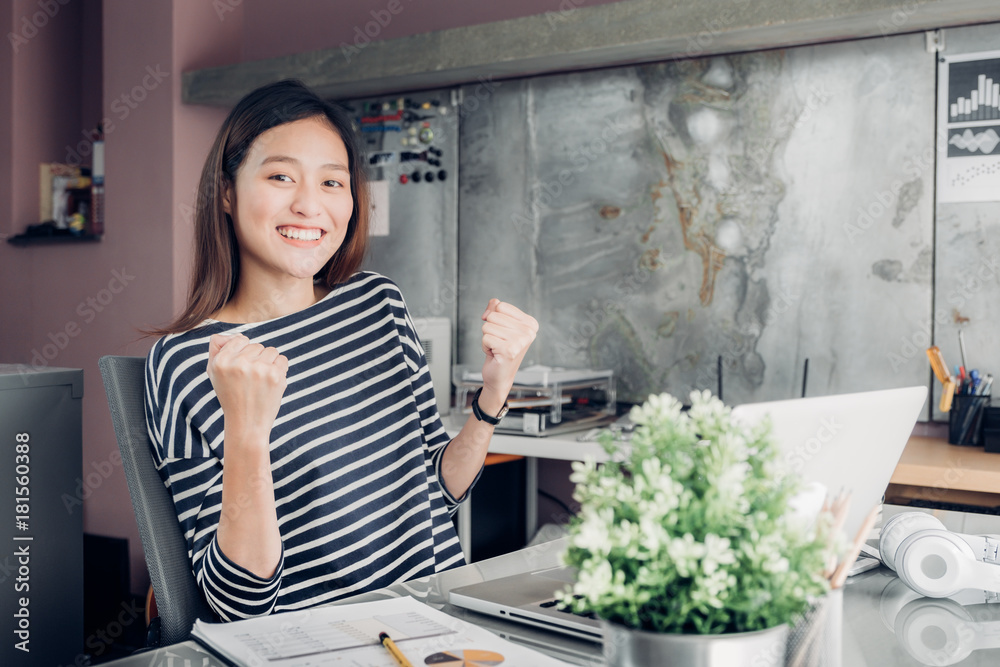 Asian creative designer hand up success with smiling face about business contract at office desk laptop,start up owner company concept. Asian creative designer hand up success with smiling face about business contract at office desk laptop,start up owner company concept.