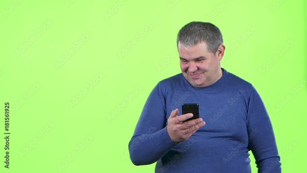 Adult man is looking at the phone for a message. Green screen. Slow motion Adult man is looking at the phone for a message. Green screen. Slow motion
