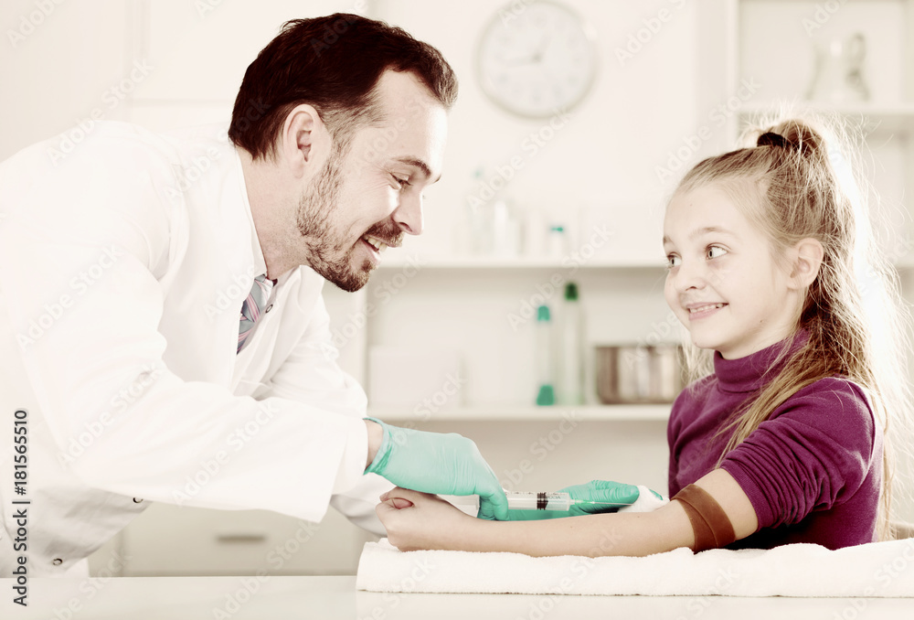 Male doctor injecting little patient