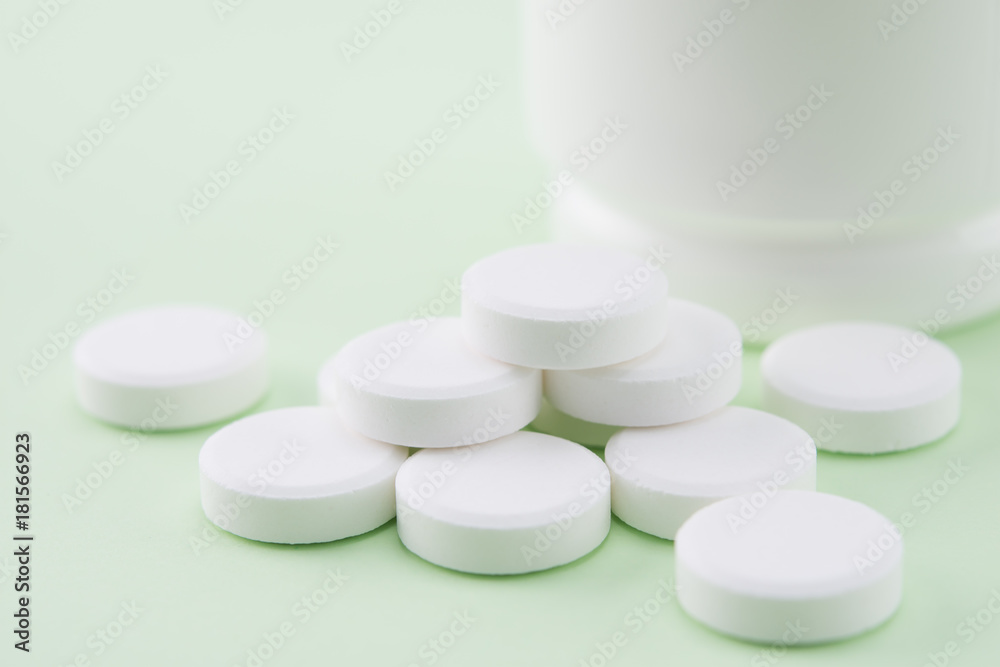 white pills and part of pill bottle, selective focus white pills and part of pill bottle, selective focus