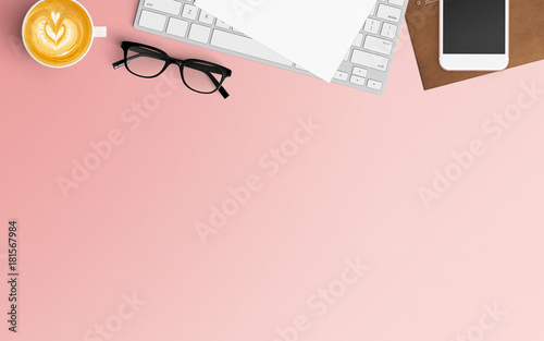 Modern workspace with coffee cup, notebook, smartphone and laptop copy space on pink color background. Top view. Flat lay style.