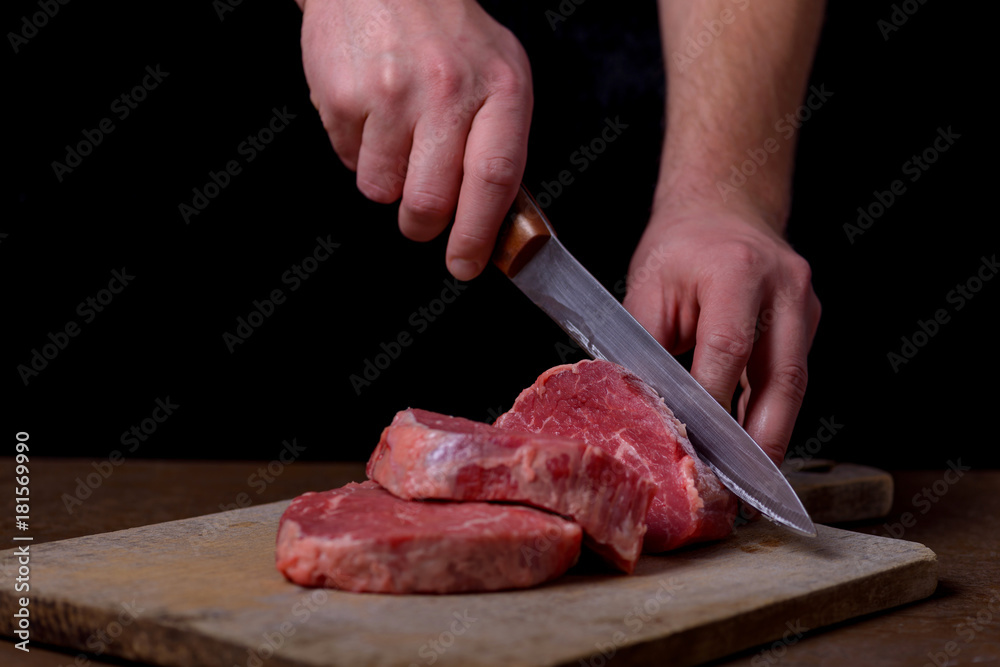 Butcher cutting beef meat on kitchen
