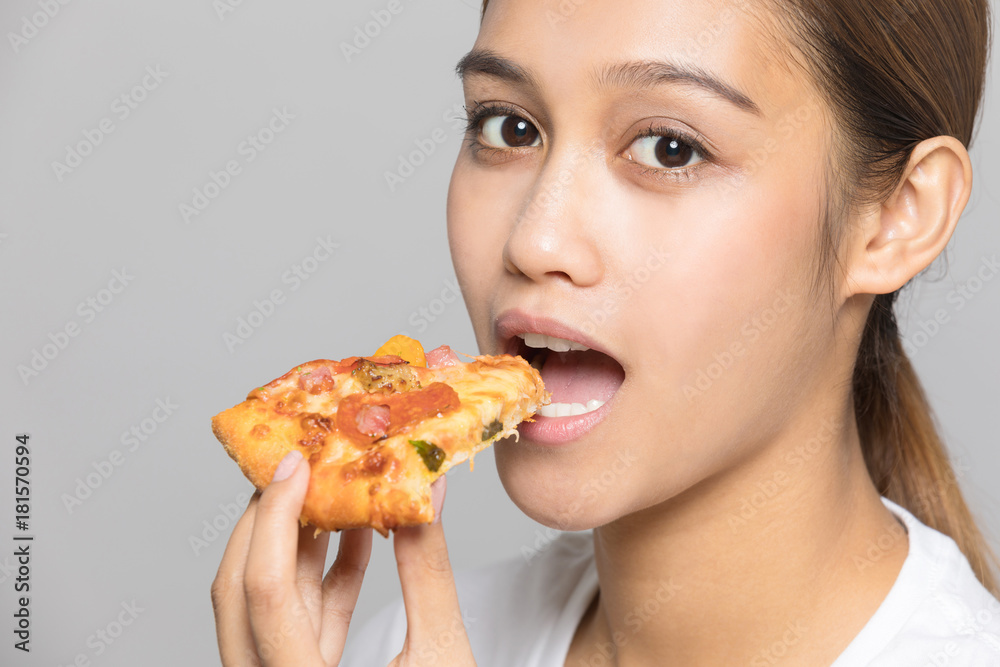 Young woman eating a slice of pizza.
