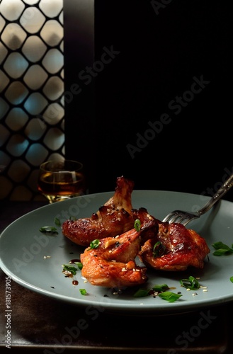 Fototapeta Naklejka Na Ścianę i Meble -  Roasted pieces chicken wings in sauce with sesame seeds and green onions