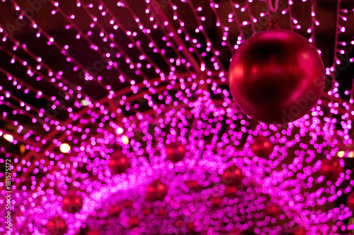 Colorful Xmas decoration of many LED light. Decorative Christmas red balls hang out on the outdoor decoration of the construction. © milkovasa