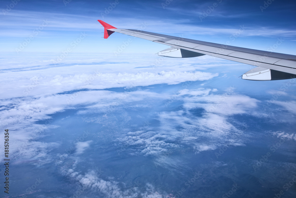 Fototapeta premium aerial view of passenger plane flying over beautiful blue sky and white cloudA