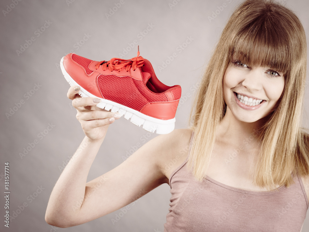 Happy woman presenting sportswear trainers shoes Happy woman presenting sportswear trainers shoes