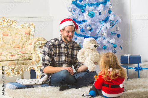 Santa claus kid and bearded man at Christmas tree.