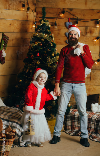 Santa claus kid and bearded man at Christmas tree.