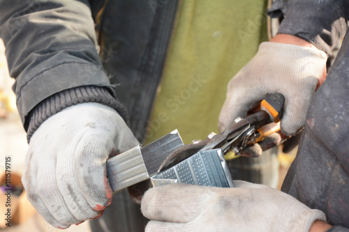 Builders cutting metal profile with metal scissors