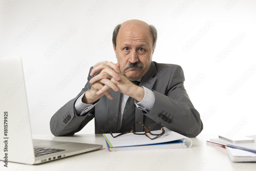 corporate portrait of 60s bald happy business man smiling confident and satisfied sitting at computer laptop office desk