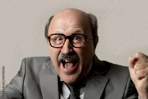 portrait of happy and excited senior mature business man on his 60s gesturing spastic and satisfied in business success and fun photo