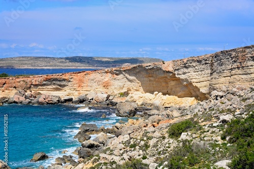 Rocky coastline with Comino to the rear, Paradise Bay, Malta.