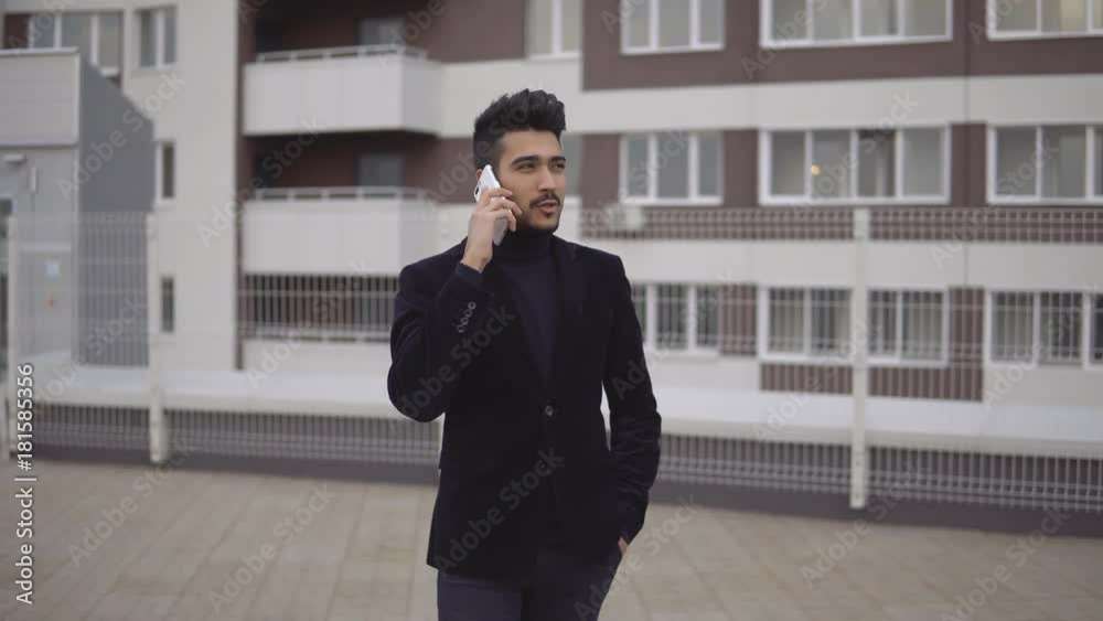 Young handsome businessman walking and talking on mobile phone in the city. Young handsome businessman walking and talking on mobile phone in the city.