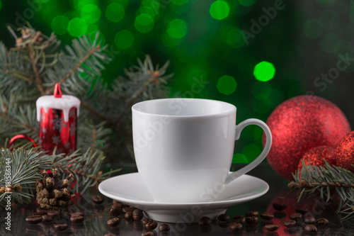 white cup of coffee in festive decoration, christmas toys, green bokeh background