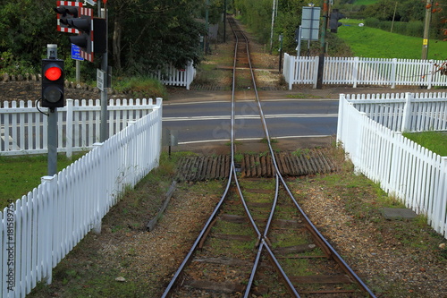 Fotografie White wooden fence  around level crossing