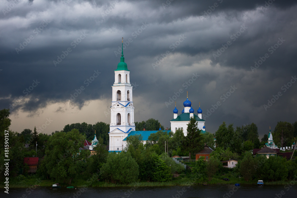 beautiful russian church on the river bank during a heavy rain