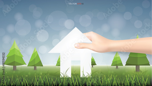 Hand pick a paper house on green yard area. Conceptual image of real estate idea. Vector illustration.