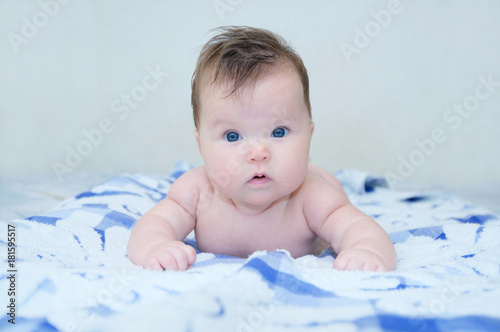 Happy baby girl portrait on bed looking at camera