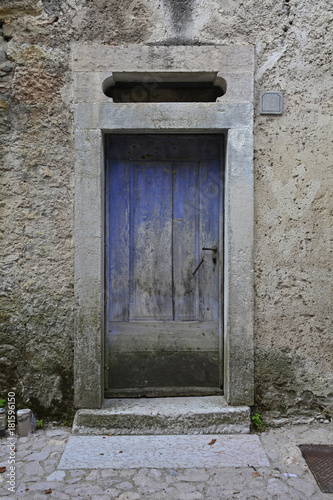 An old wooden door in a derelict building the historic hill village of Erto in Friuli Venezia Giulia, north east Italy   © dragoncello