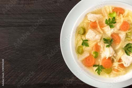 Chicken soup with noodles, overhead closeup photo with copyspace
