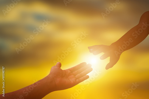 Silhouette of helping hand at sunset,please help me.helping and teamwork concept.