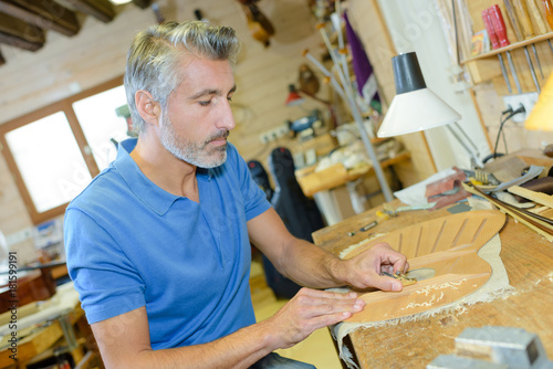 Obraz na plátně Musical instrument maker at workbench